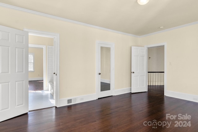 empty room with dark hardwood / wood-style flooring and ornamental molding