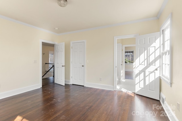 unfurnished bedroom featuring dark hardwood / wood-style floors and ornamental molding