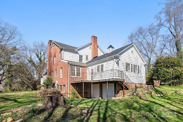 rear view of property featuring a wooden deck, a yard, and a garage