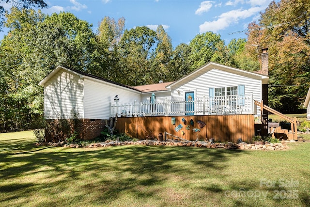 rear view of house featuring a deck and a yard