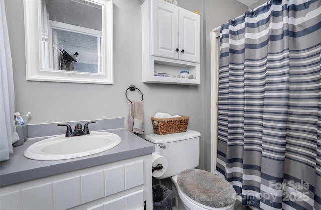 bathroom featuring a shower with shower curtain, vanity, and toilet