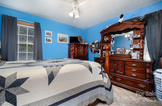 bedroom with carpet, ceiling fan, and a textured ceiling