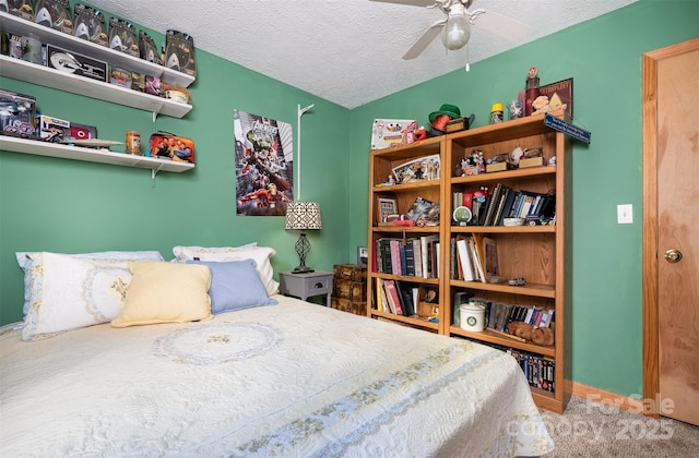 carpeted bedroom featuring ceiling fan and a textured ceiling