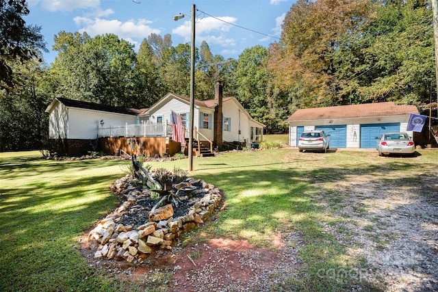 view of yard with a garage and an outbuilding