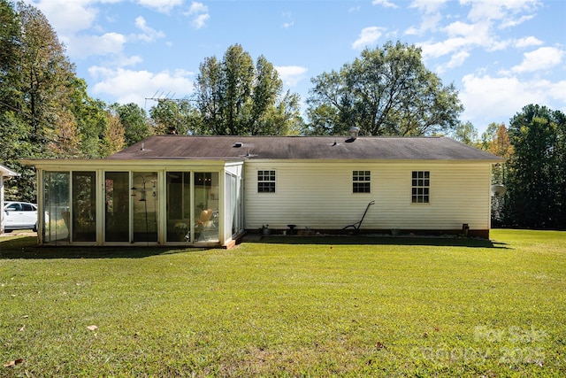 back of property featuring a lawn and a sunroom