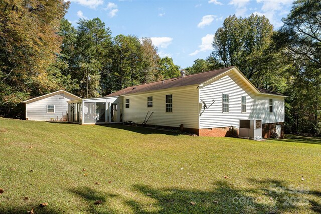 back of property featuring a lawn and a sunroom