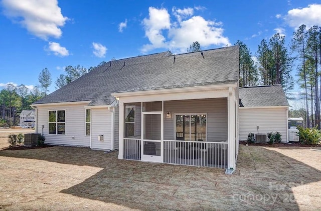 back of property with central AC and a sunroom