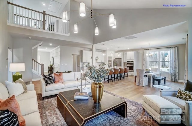 living room featuring high vaulted ceiling and light hardwood / wood-style floors