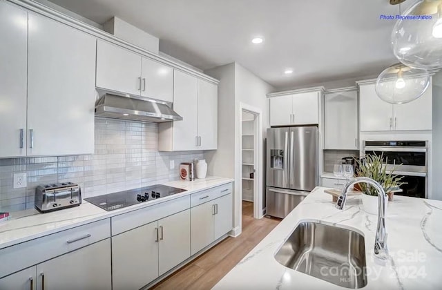 kitchen featuring black electric stovetop, stainless steel fridge with ice dispenser, hanging light fixtures, backsplash, and white cabinetry