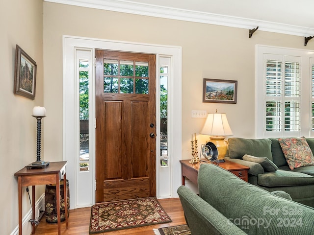 entrance foyer featuring ornamental molding and light hardwood / wood-style flooring