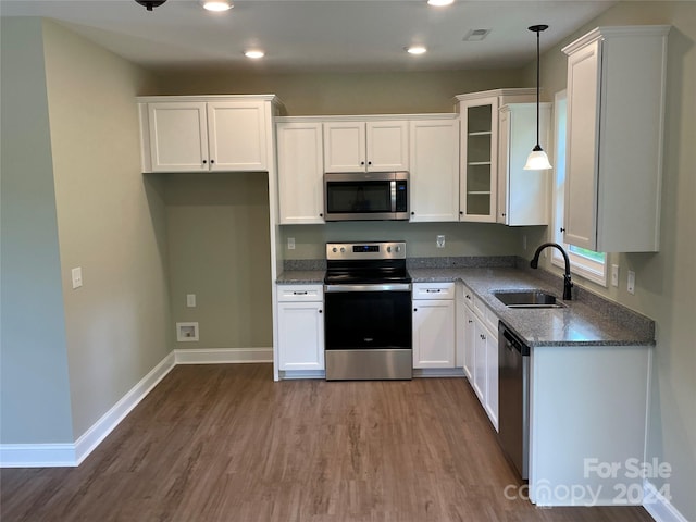 kitchen featuring white cabinets, pendant lighting, sink, and appliances with stainless steel finishes