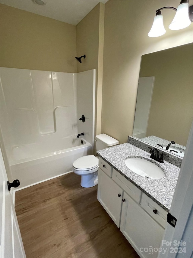 full bathroom with shower / tub combination, vanity, wood-type flooring, and toilet