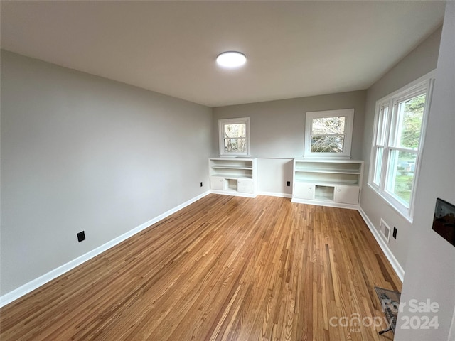 unfurnished living room with plenty of natural light and light hardwood / wood-style flooring