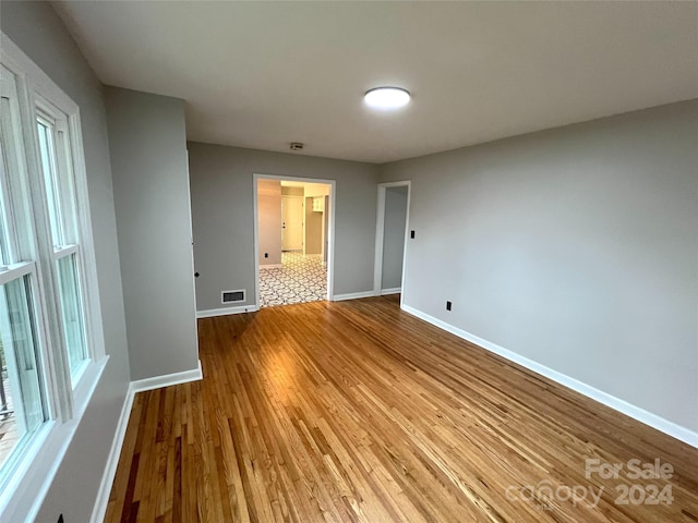 unfurnished room with hardwood / wood-style flooring and a healthy amount of sunlight