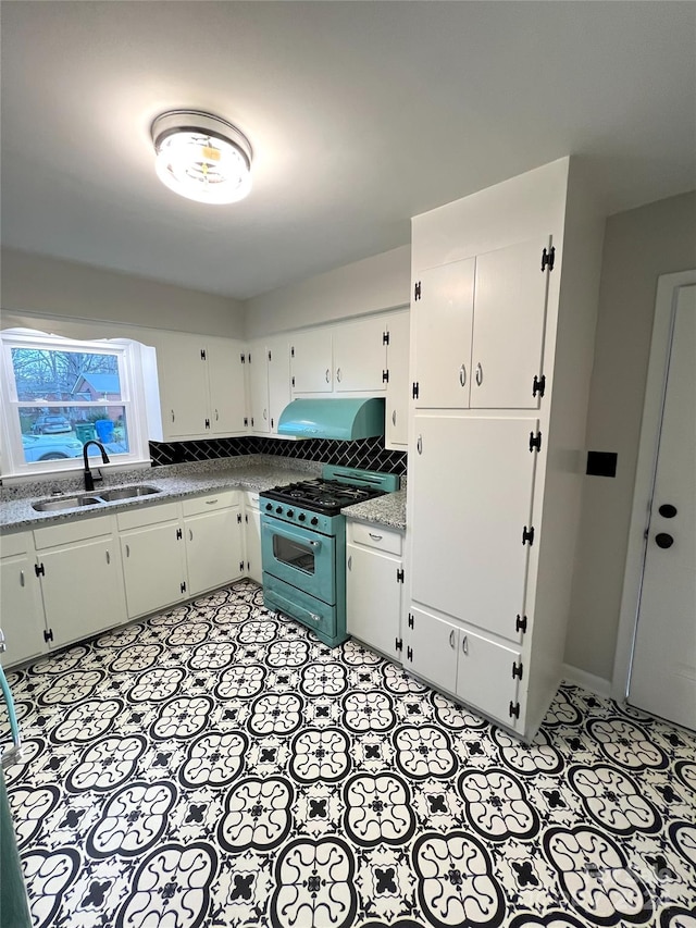 kitchen featuring gas stove, light tile flooring, and sink