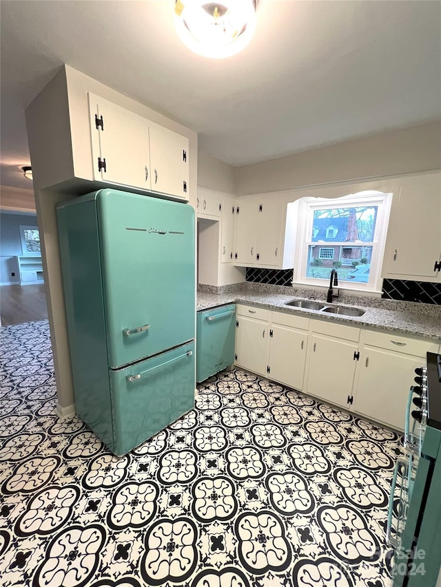 kitchen featuring light tile floors, white refrigerator, white cabinetry, dishwasher, and sink