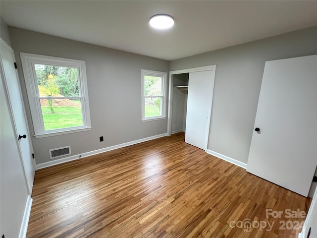 unfurnished bedroom with light hardwood / wood-style flooring and a closet