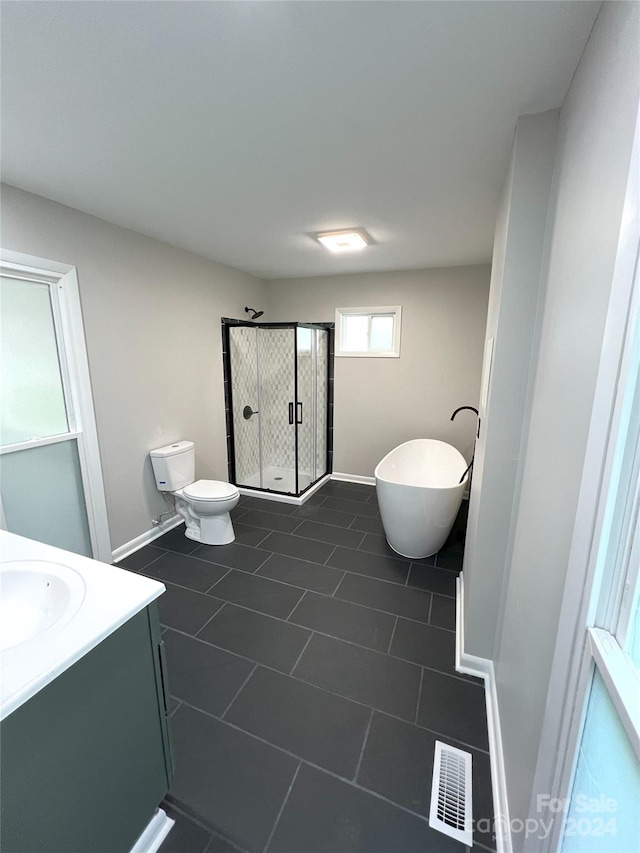 bathroom with toilet, tile floors, and vanity