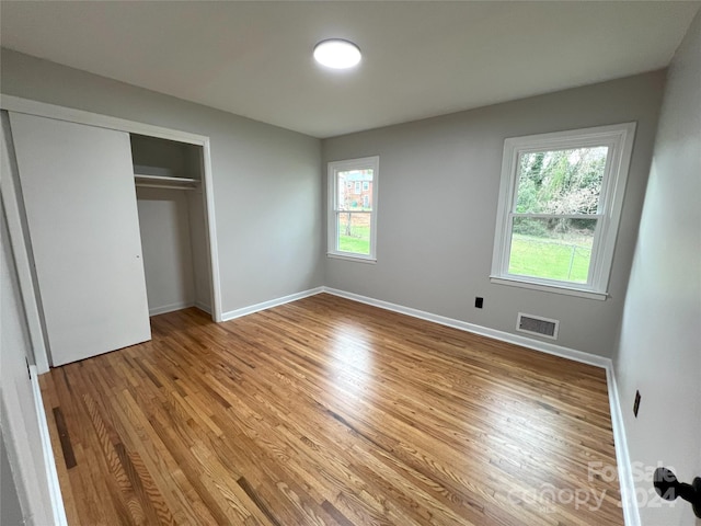 unfurnished bedroom with light hardwood / wood-style floors and a closet