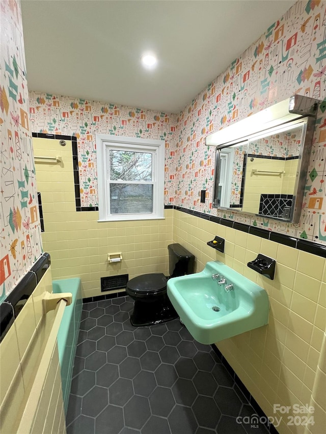 bathroom featuring sink, tile floors, toilet, and tile walls