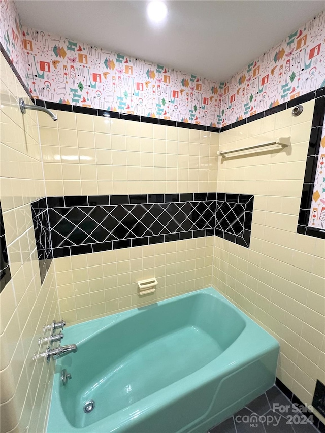 bathroom with tile walls and tiled shower / bath