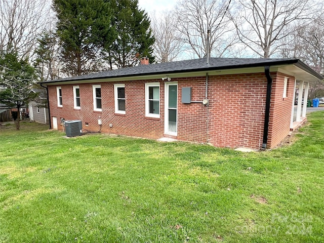 exterior space with central air condition unit and a yard