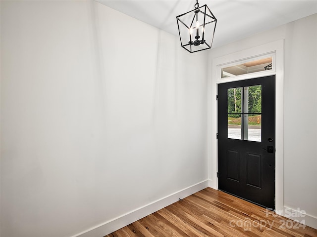 doorway with an inviting chandelier and light wood-type flooring