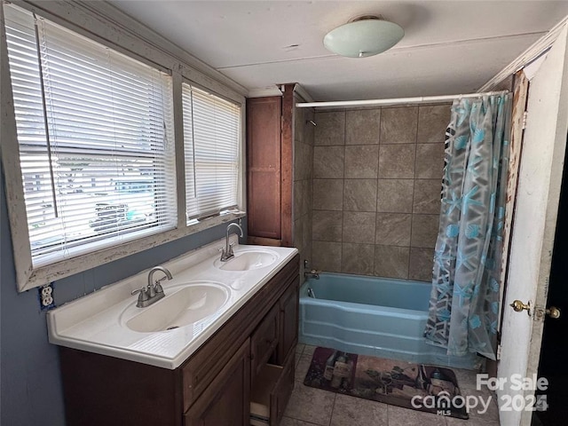 bathroom with tile patterned floors, shower / bath combo with shower curtain, and vanity