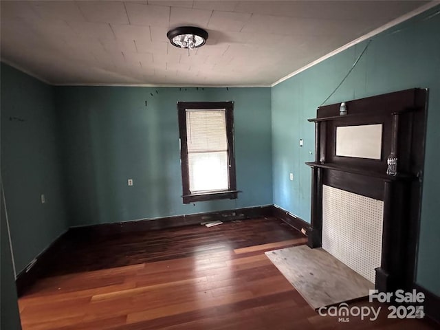 empty room featuring ornamental molding and wood-type flooring