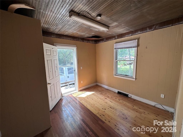 empty room with hardwood / wood-style floors and wooden ceiling