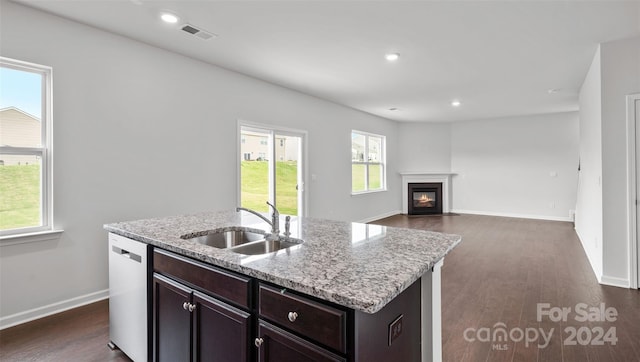 kitchen featuring an island with sink, a wealth of natural light, and dark wood-type flooring