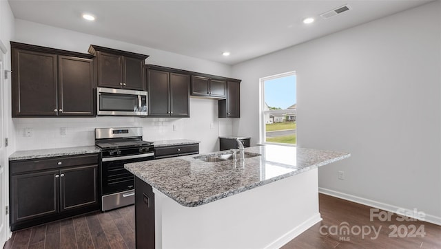 kitchen with sink, stainless steel appliances, dark hardwood / wood-style flooring, and a kitchen island with sink