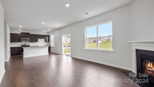 unfurnished living room with dark hardwood / wood-style floors and sink