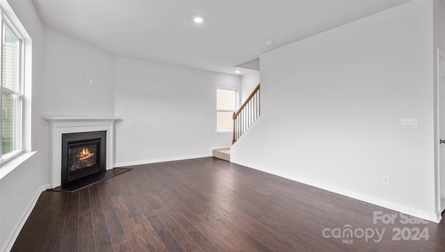 unfurnished living room with a healthy amount of sunlight and dark wood-type flooring