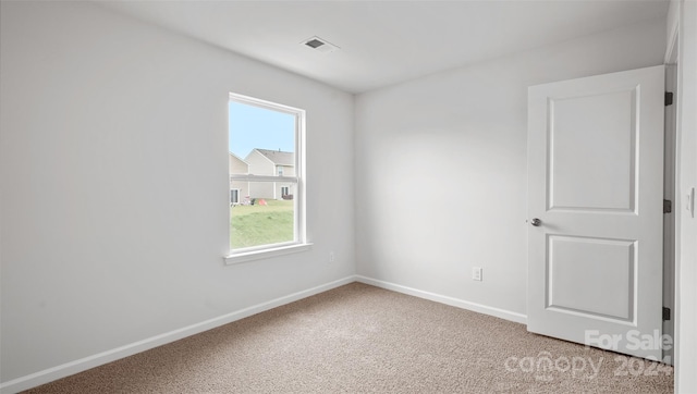 spare room featuring light colored carpet