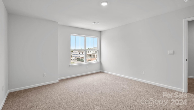 unfurnished room featuring light colored carpet