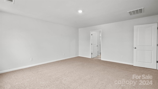 spare room featuring light carpet