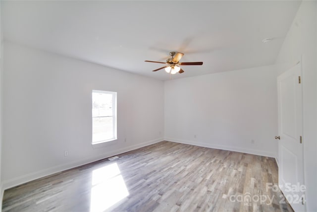 empty room with ceiling fan and light wood-type flooring