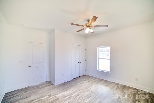 unfurnished bedroom featuring light hardwood / wood-style floors, a closet, and ceiling fan