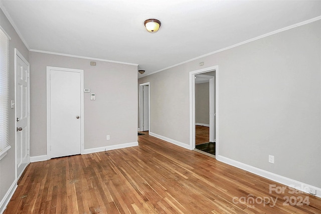 unfurnished bedroom featuring ornamental molding and hardwood / wood-style floors