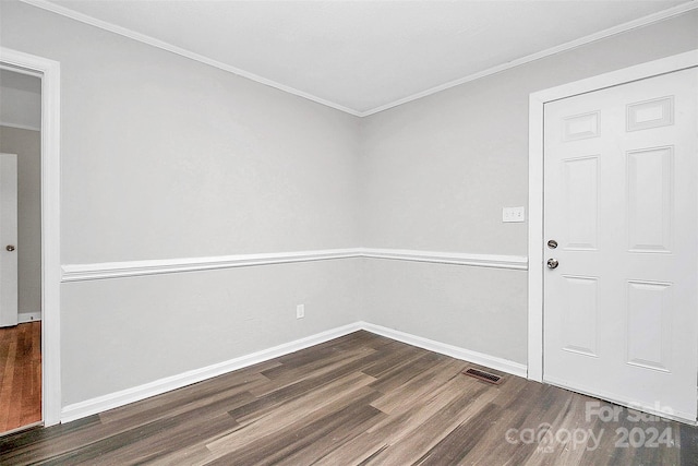 empty room with ornamental molding and dark hardwood / wood-style floors