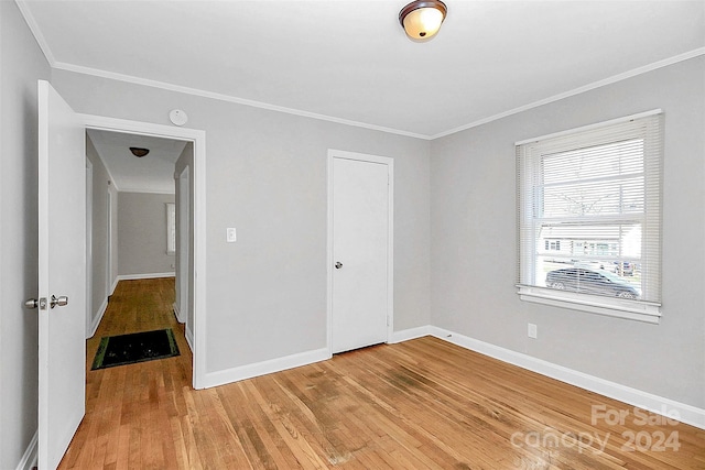 spare room with ornamental molding and hardwood / wood-style floors