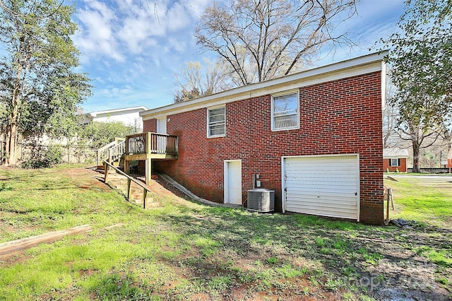 back of property with a garage, a deck, and a lawn