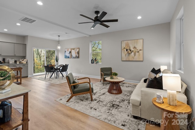 living room featuring ceiling fan, a healthy amount of sunlight, and light hardwood / wood-style flooring