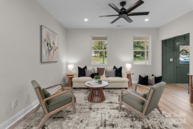 living room with ceiling fan and light hardwood / wood-style flooring