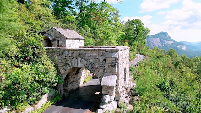 exterior space featuring a mountain view and an outdoor stone fireplace