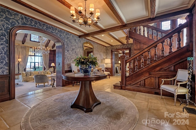 foyer entrance with light tile flooring, beam ceiling, and a chandelier