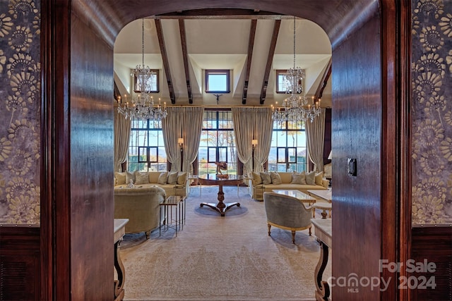 interior space with beamed ceiling, a high ceiling, and an inviting chandelier