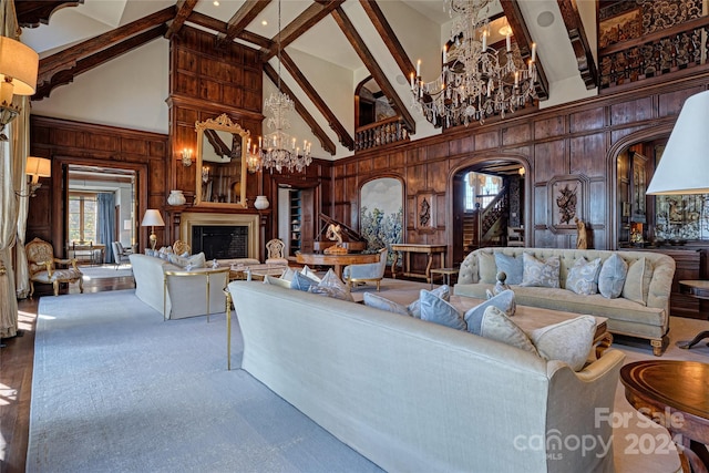 living room with wood walls, high vaulted ceiling, and an inviting chandelier