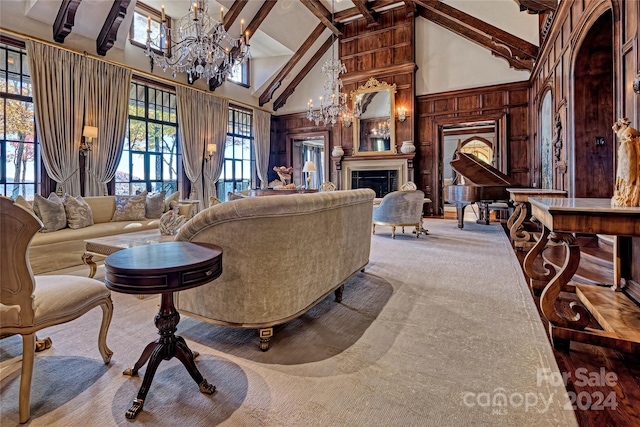 living room featuring wood walls, high vaulted ceiling, beam ceiling, light carpet, and an inviting chandelier